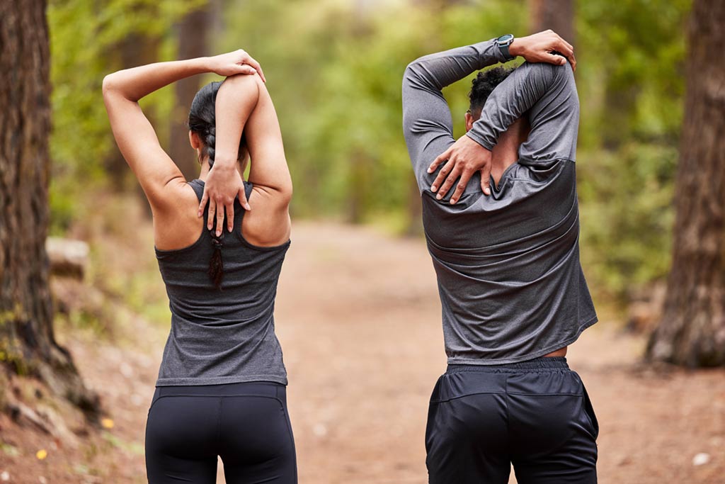 Pareja realizando estiramientos antes de hacer deporte