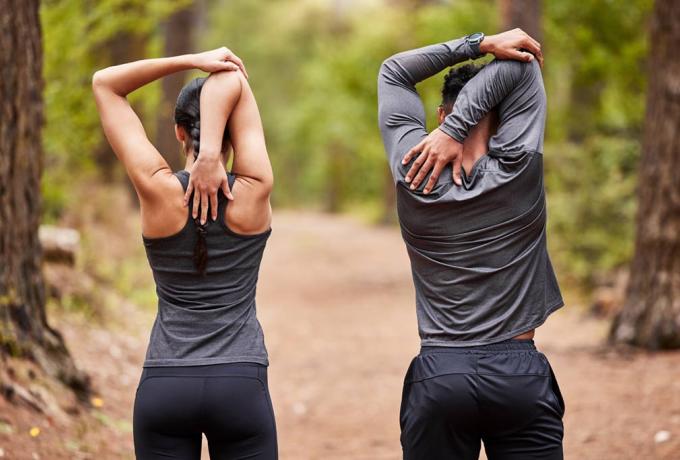 Pareja realizando estiramientos antes de hacer deporte