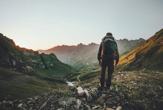 Senderista contemplando montañas al atardecer